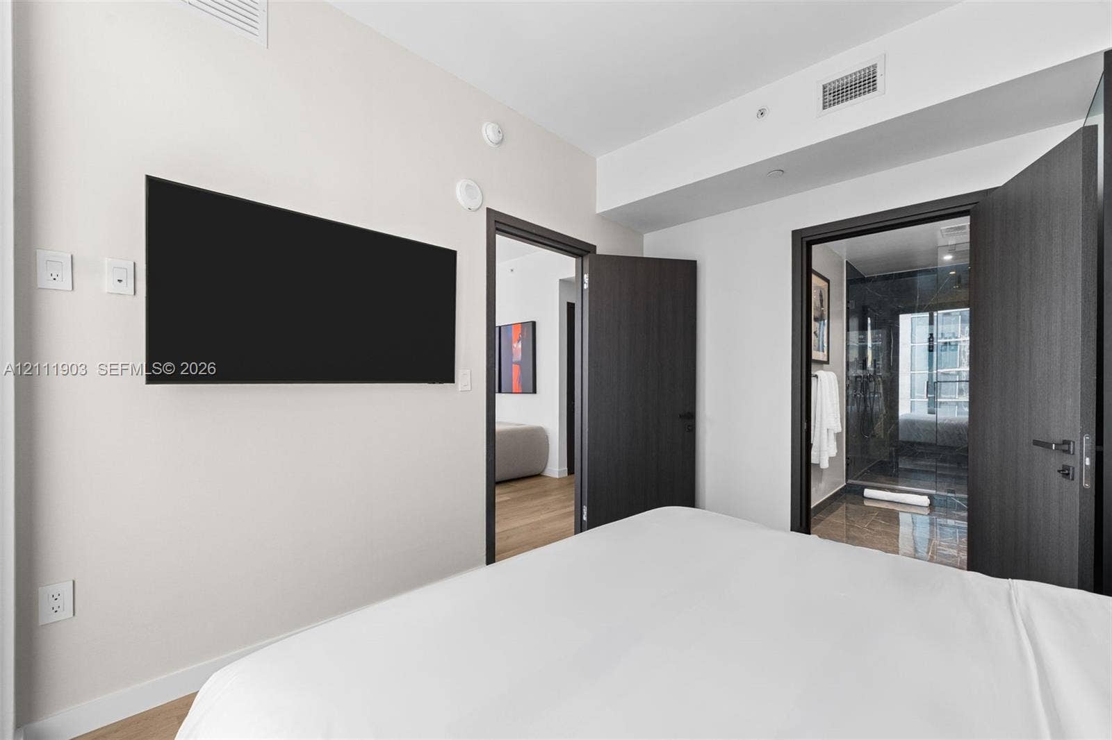 20 NE 11th Street, #4308, Miami, FL 33132 Interior room featuring dark-toned solid core doors, minimalist hardware, and wood-finish flooring