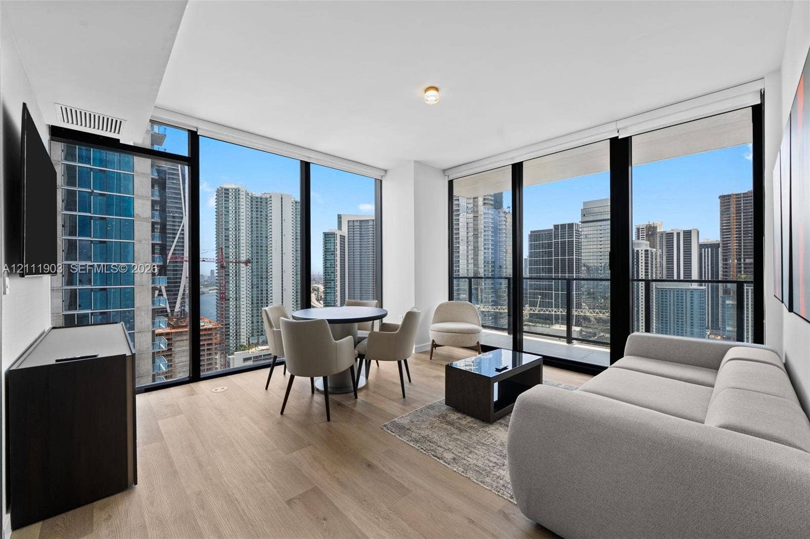 20 NE 11th Street, #4308, Miami, FL 33132 Floor-to-ceiling windows with panoramic urban skyscraper scenery, wood-finish flooring, and recessed ceiling lighting