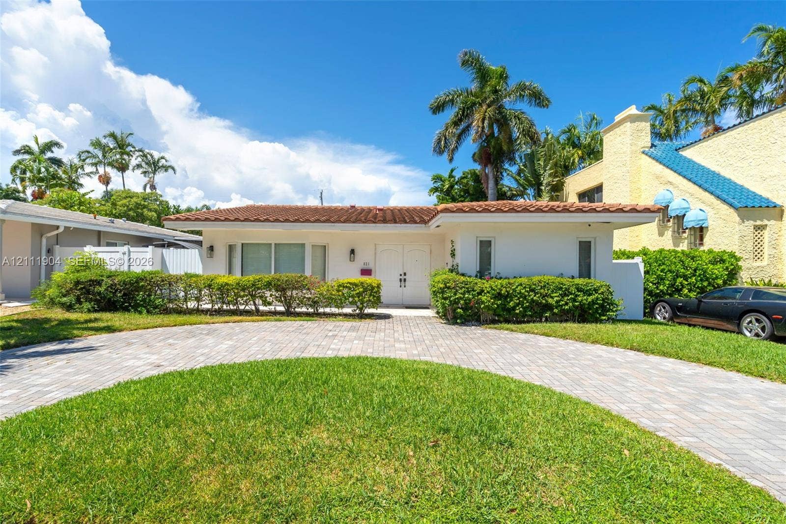 821 Harrison Street, Hollywood, FL 33019 Single-story exterior featuring a terracotta-tiled roof, paver driveway, manicured landscaping, and double-entry front doors
