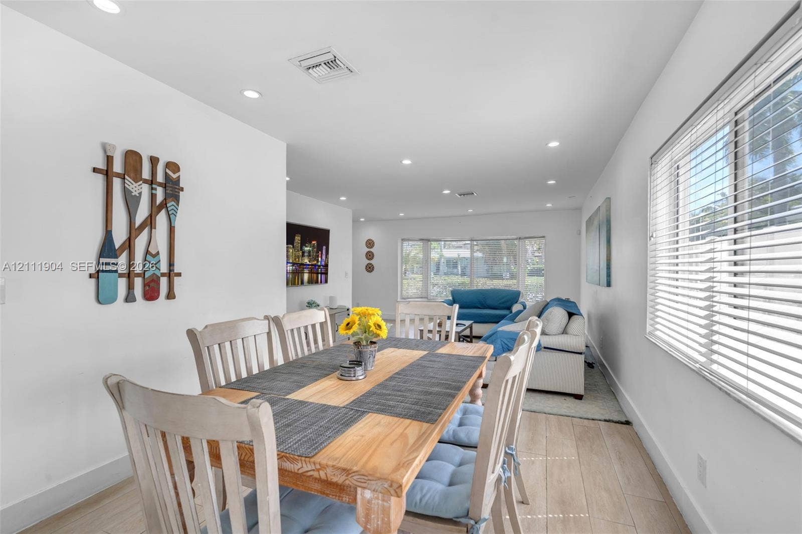 821 Harrison Street, Hollywood, FL 33019 Open-concept living space featuring wood-finish flooring, recessed lighting, and large windows with horizontal blinds