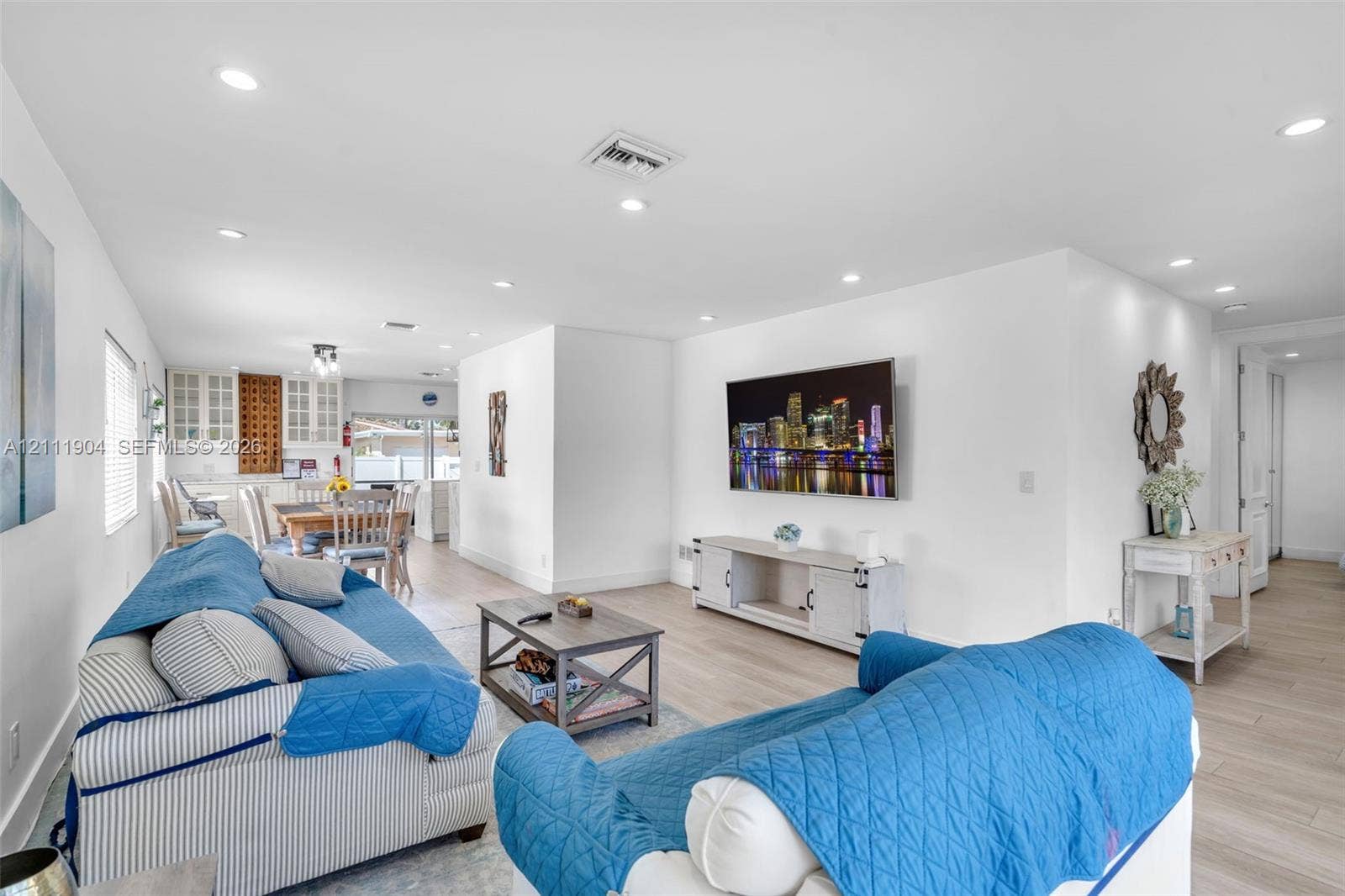 821 Harrison Street, Hollywood, FL 33019 Open-concept interior featuring light-toned wood-finish flooring, recessed lighting, and white cabinetry with glass-front display uppers