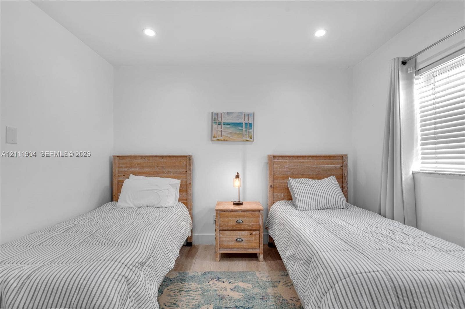 821 Harrison Street, Hollywood, FL 33019 Neutral-toned room featuring recessed ceiling lighting, wood-finish flooring, and a horizontal window with adjustable blinds