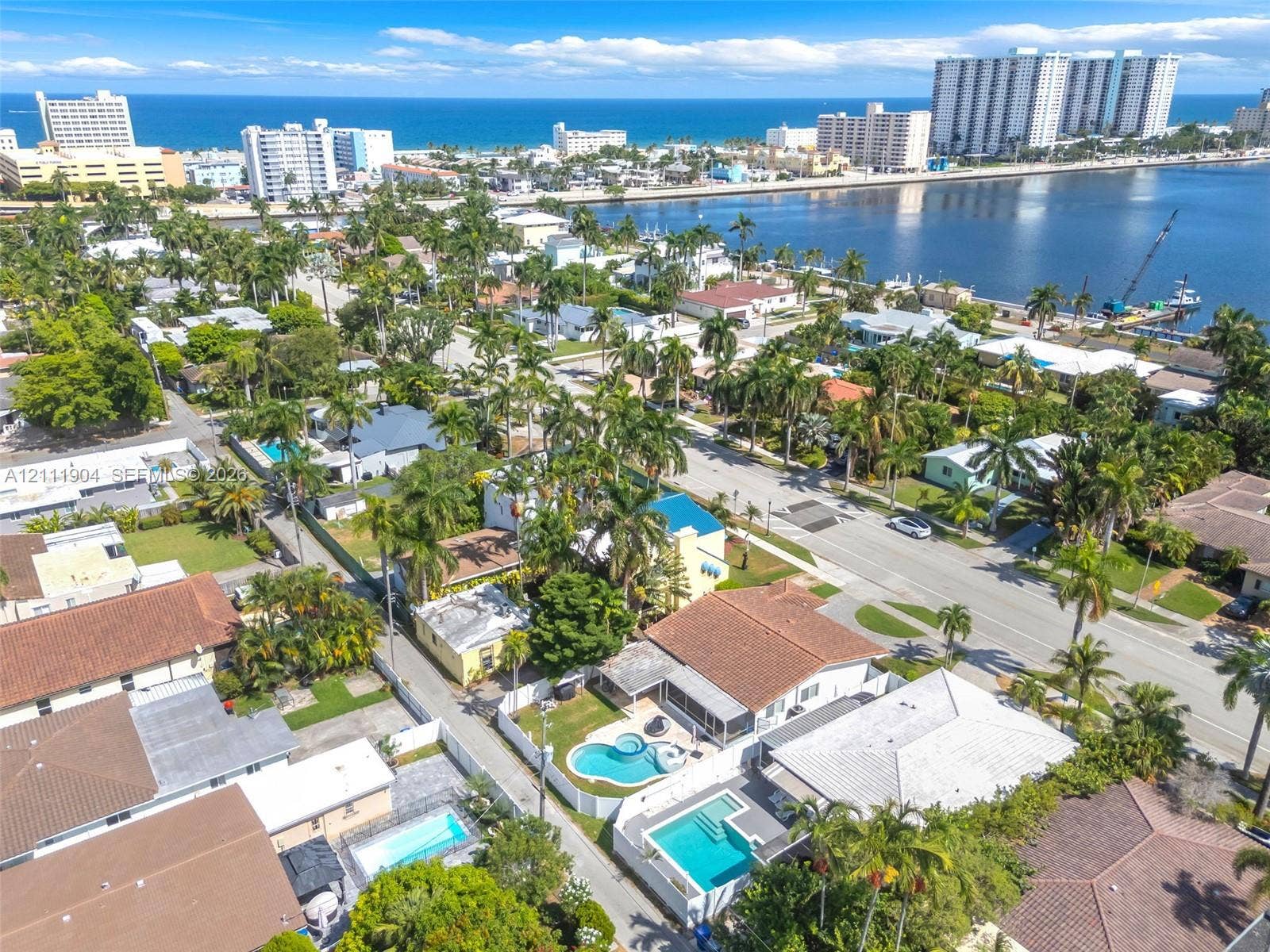 821 Harrison Street, Hollywood, FL 33019 Aerial perspective of a coastal residential neighborhood featuring palm tree-lined streets, proximity to the coastline, and private swimming pools
