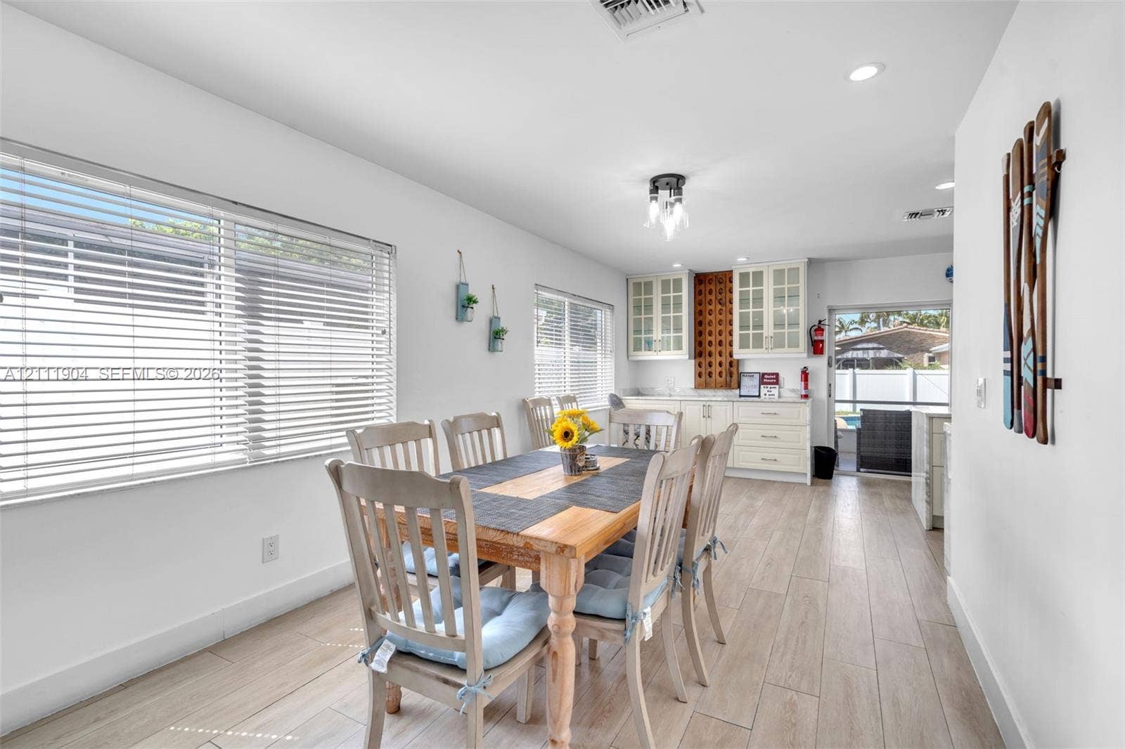 821 Harrison Street, Hollywood, FL 33019 Ceramic tile flooring, white shaker-style cabinetry with glass-front uppers, recessed ceiling lighting, and horizontal window blinds