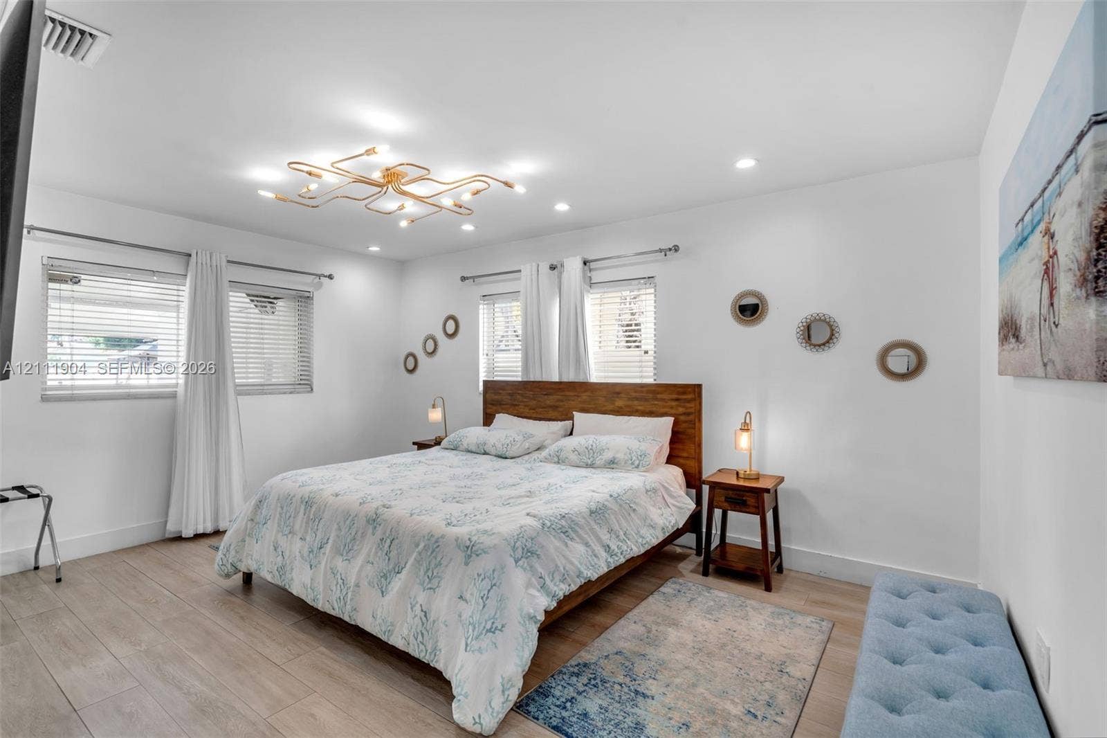 821 Harrison Street, Hollywood, FL 33019 Room featuring wood-finish flooring, recessed lighting, a modern geometric ceiling fixture, and dual windows with horizontal blinds