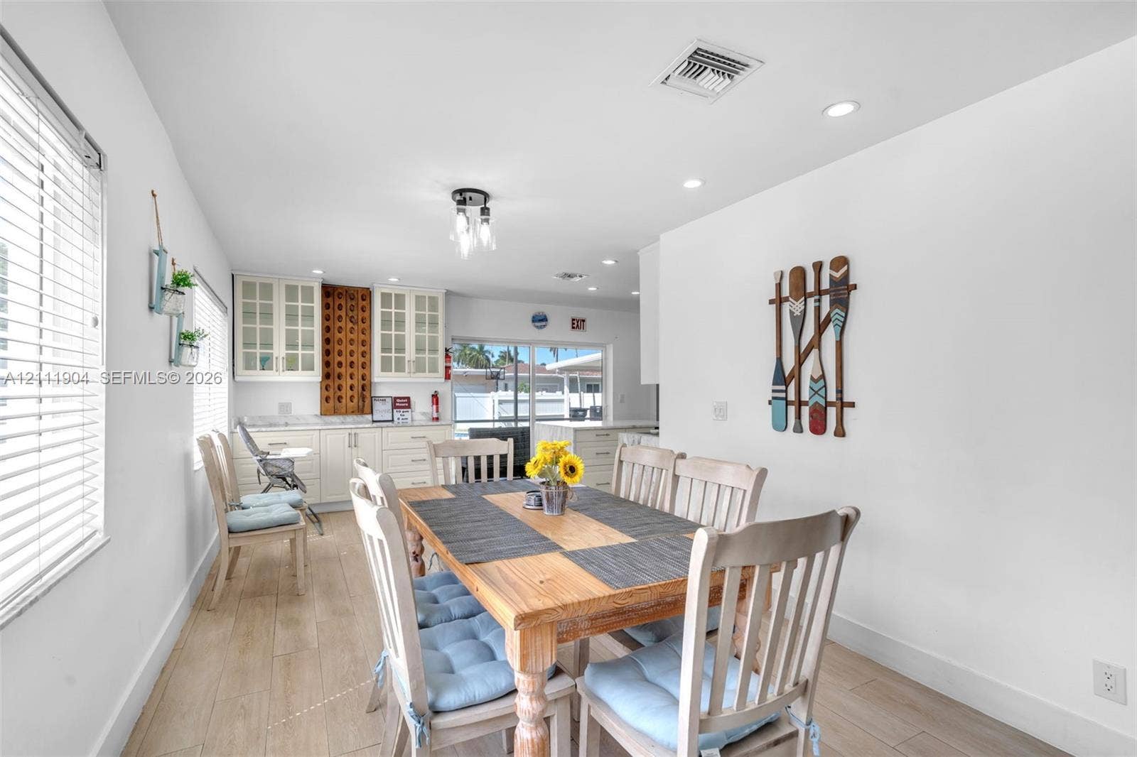 821 Harrison Street, Hollywood, FL 33019 Kitchen area featuring white cabinetry with glass-paneled upper doors, wood-finish flooring, recessed lighting, and a multi-light fixture