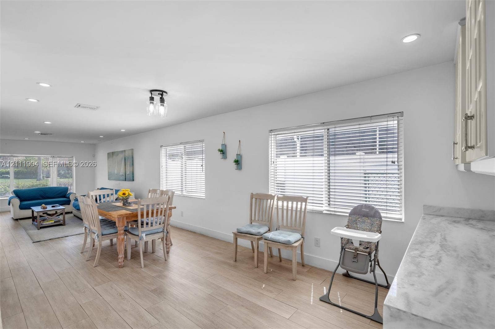 821 Harrison Street, Hollywood, FL 33019 Open-concept space featuring wood-finish flooring, recessed lighting, expansive windows with horizontal blinds, and stone-finish countertops