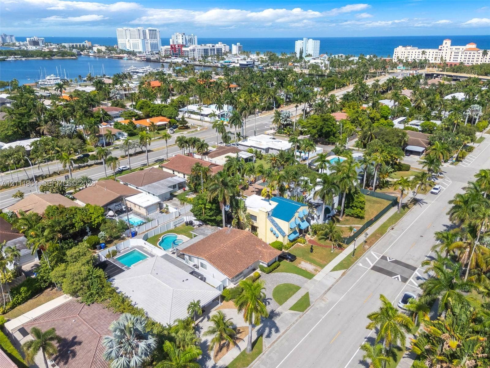 821 Harrison Street, Hollywood, FL 33019 Aerial perspective of coastal residential property featuring mature palm landscaping, paved driveway, and proximity to the waterfront
