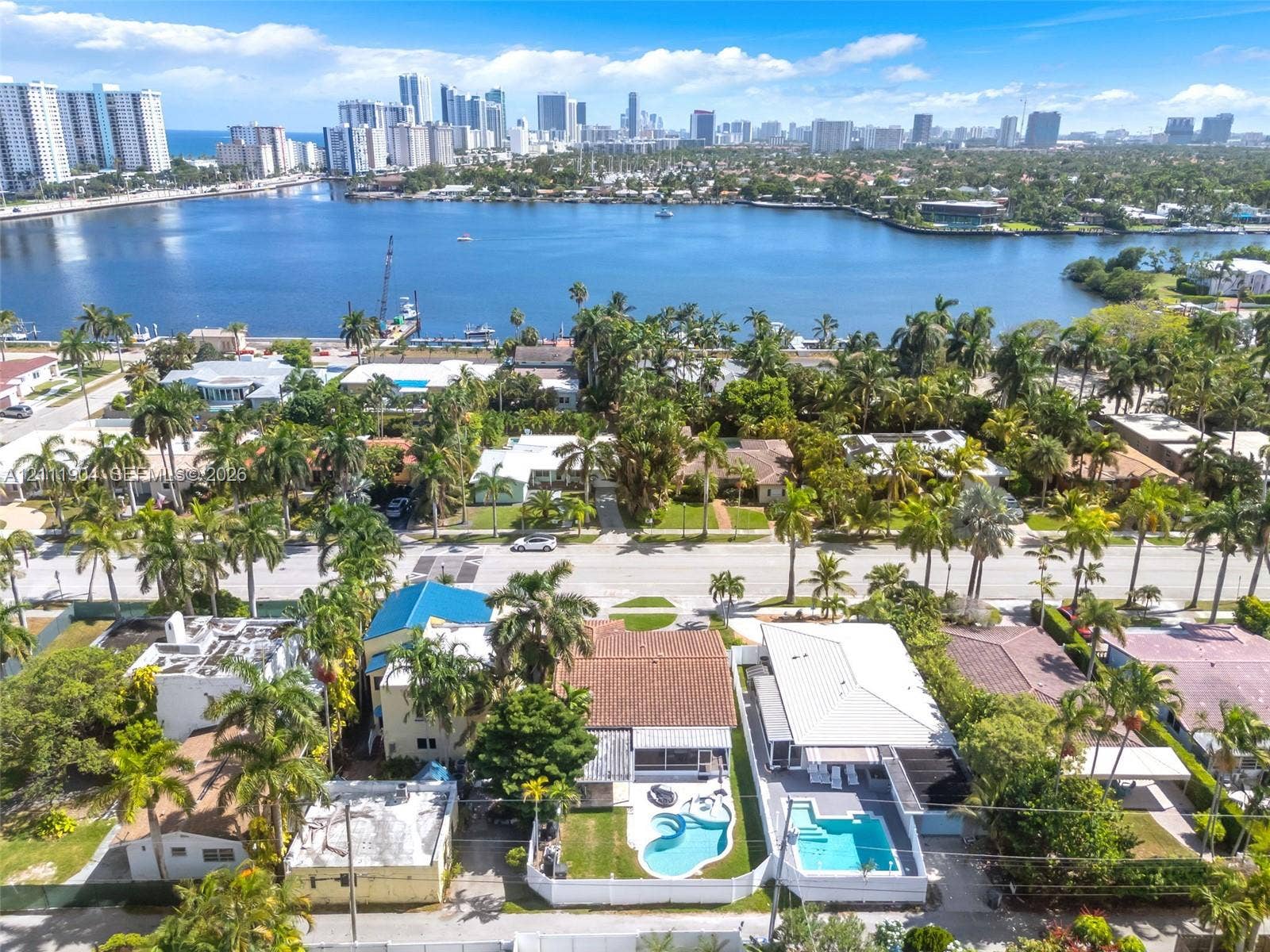 821 Harrison Street, Hollywood, FL 33019 Aerial perspective of a coastal residential neighborhood featuring mature palm trees and direct proximity to the intracoastal waterway and city skyline