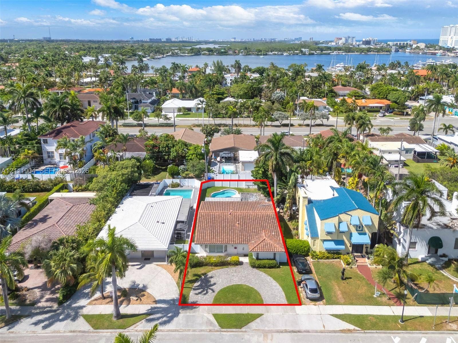 821 Harrison Street, Hollywood, FL 33019 Single-story residence featuring a clay tile roof, a circular paver driveway, and a backyard swimming pool