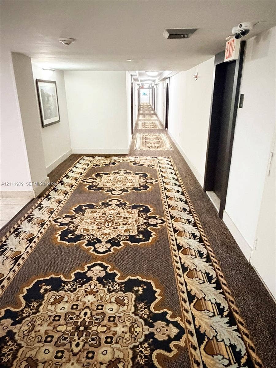 2851 NE 183rd Street, #1708E, Aventura, FL 33160 Hallway featuring patterned carpet flooring, recessed ceiling lighting, and a metal elevator door