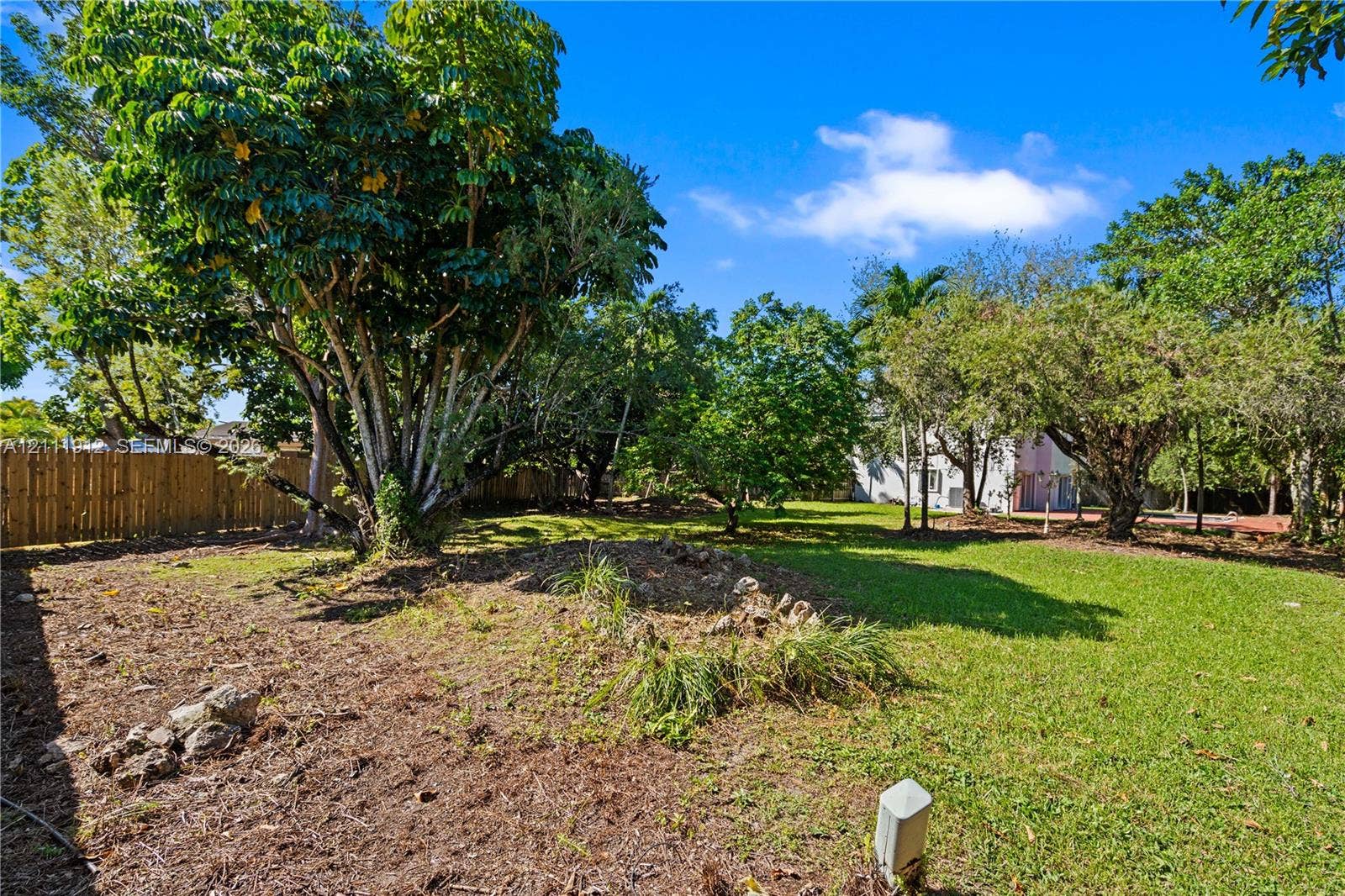 15681 SW 147th Court, Miami, FL 33187 Expansive lot featuring mature trees, manicured lawn areas, and perimeter wood fencing
