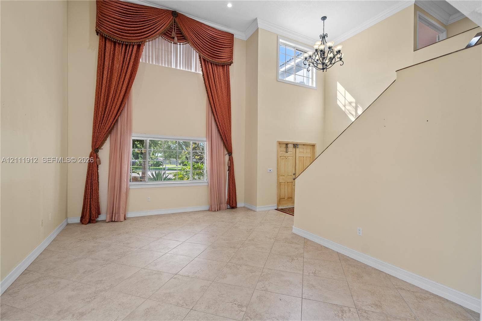 15681 SW 147th Court, Miami, FL 33187 Two-story foyer featuring tile flooring, a multi-tiered chandelier, and large windows with transom