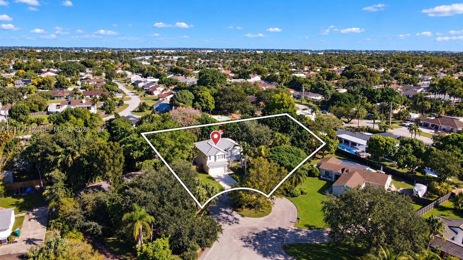 15681 SW 147th Court, Miami, FL 33187 Aerial perspective of a multi-story residence situated on a corner lot featuring a concrete driveway, two-car garage, and established perimeter landscaping