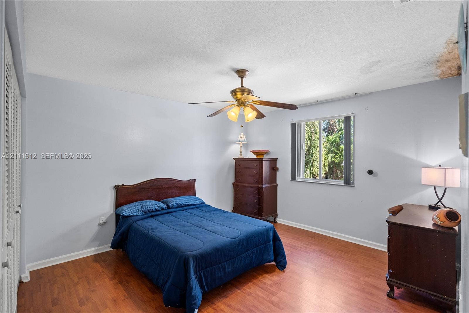 15681 SW 147th Court, Miami, FL 33187 Room featuring wood-finish flooring, a ceiling fan with integrated lighting, and a window with exterior greenery