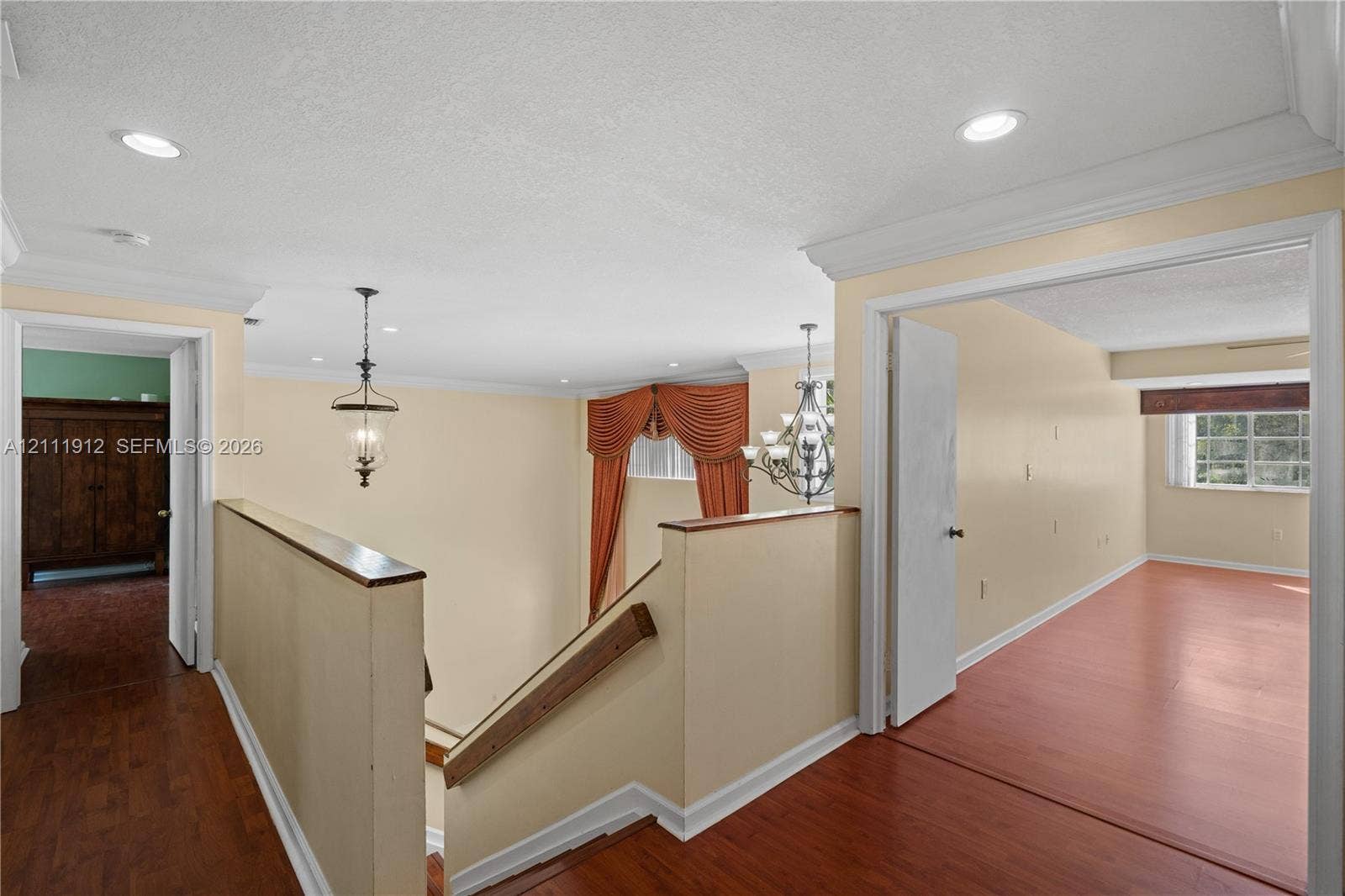 15681 SW 147th Court, Miami, FL 33187 Interior landing featuring wood-finish flooring, recessed lighting, crown molding, a decorative metal chandelier, and a wood-capped half wall
