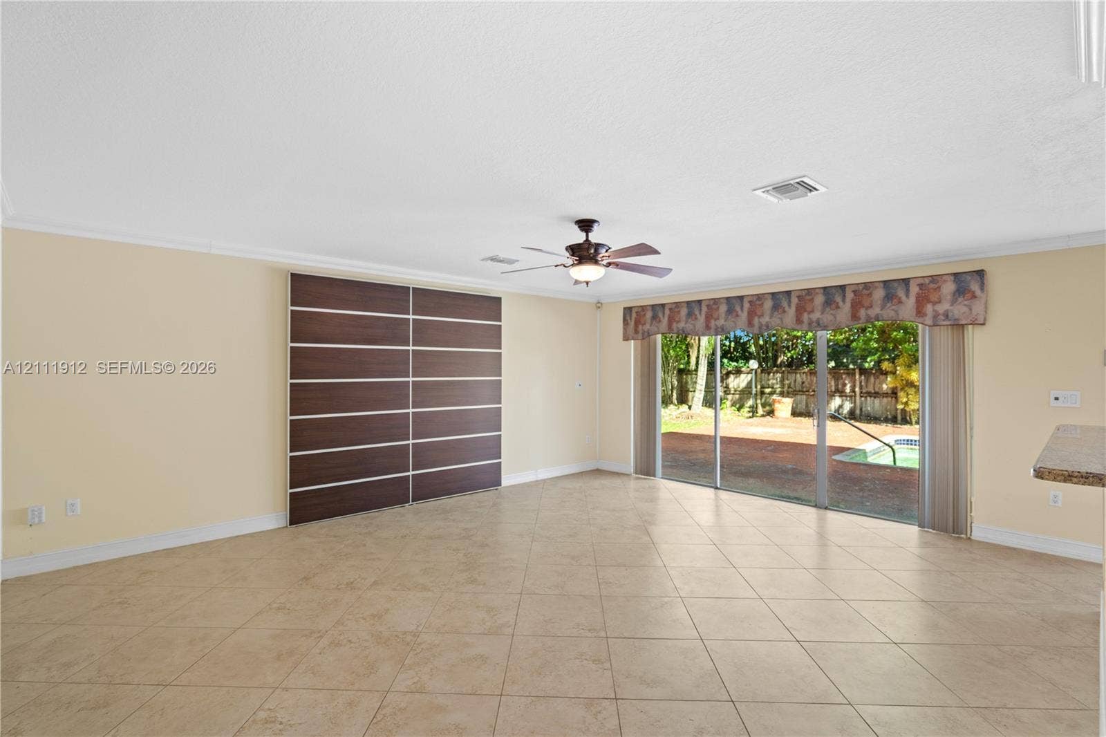 15681 SW 147th Court, Miami, FL 33187 Tile flooring, custom floor-to-ceiling sliding cabinetry, ceiling fan, and oversized sliding glass doors