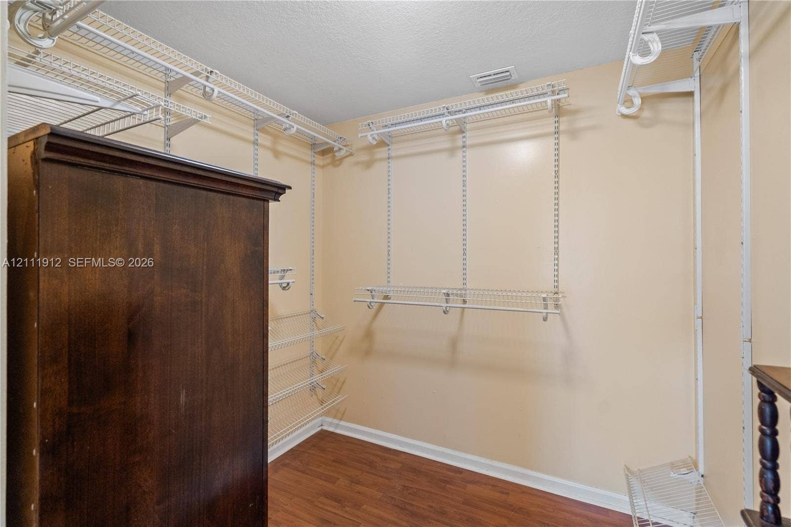 15681 SW 147th Court, Miami, FL 33187 Walk-in closet featuring wood-finish flooring and tiered white wire shelving