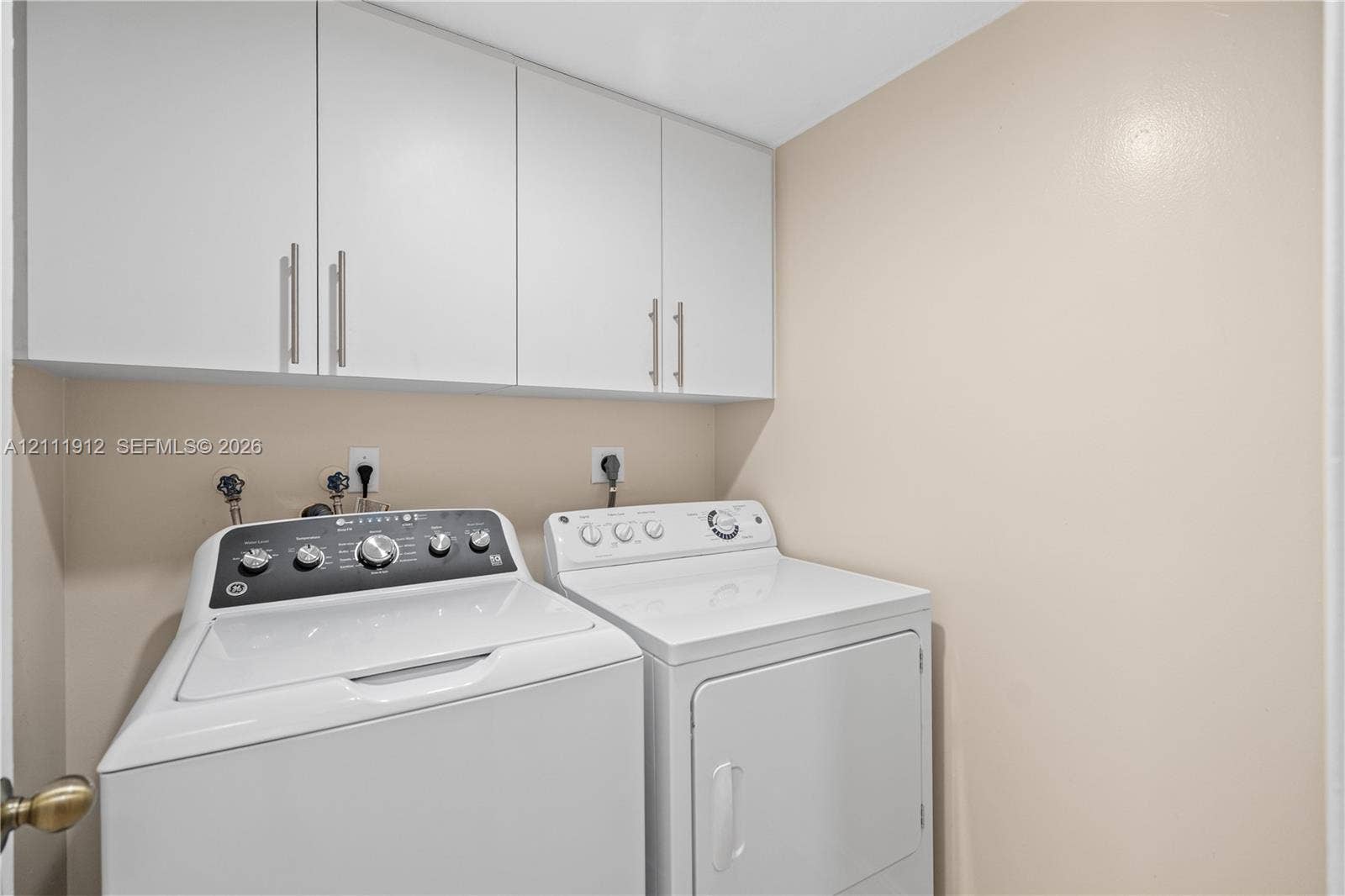 15681 SW 147th Court, Miami, FL 33187 Laundry area featuring white cabinetry with brushed-metal pulls and dedicated utility hookups