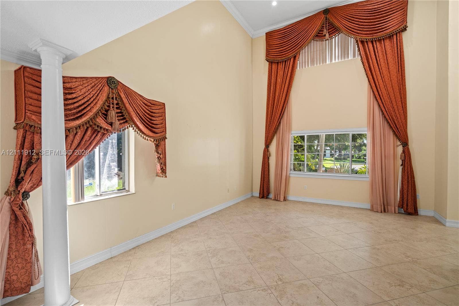 15681 SW 147th Court, Miami, FL 33187 Vaulted ceilings featuring expansive windows, neutral tile flooring, and a decorative column