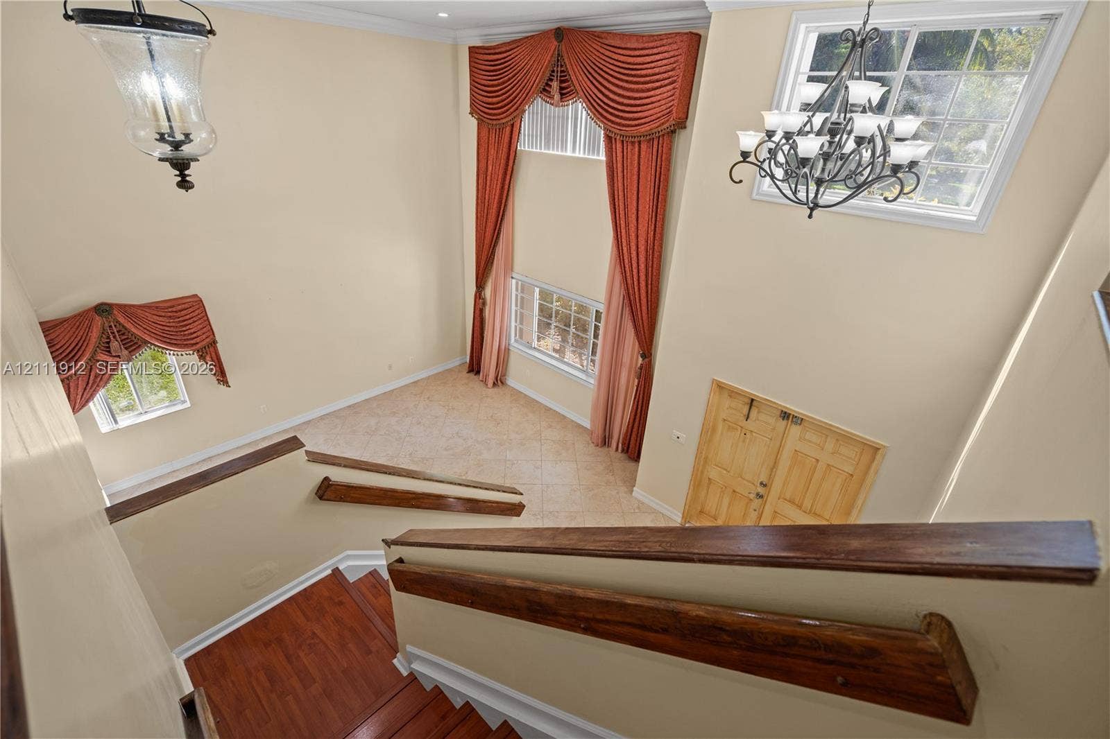 15681 SW 147th Court, Miami, FL 33187 Double-height foyer featuring a staircase with wood-finish handrails, tile flooring, and multi-tiered decorative chandeliers