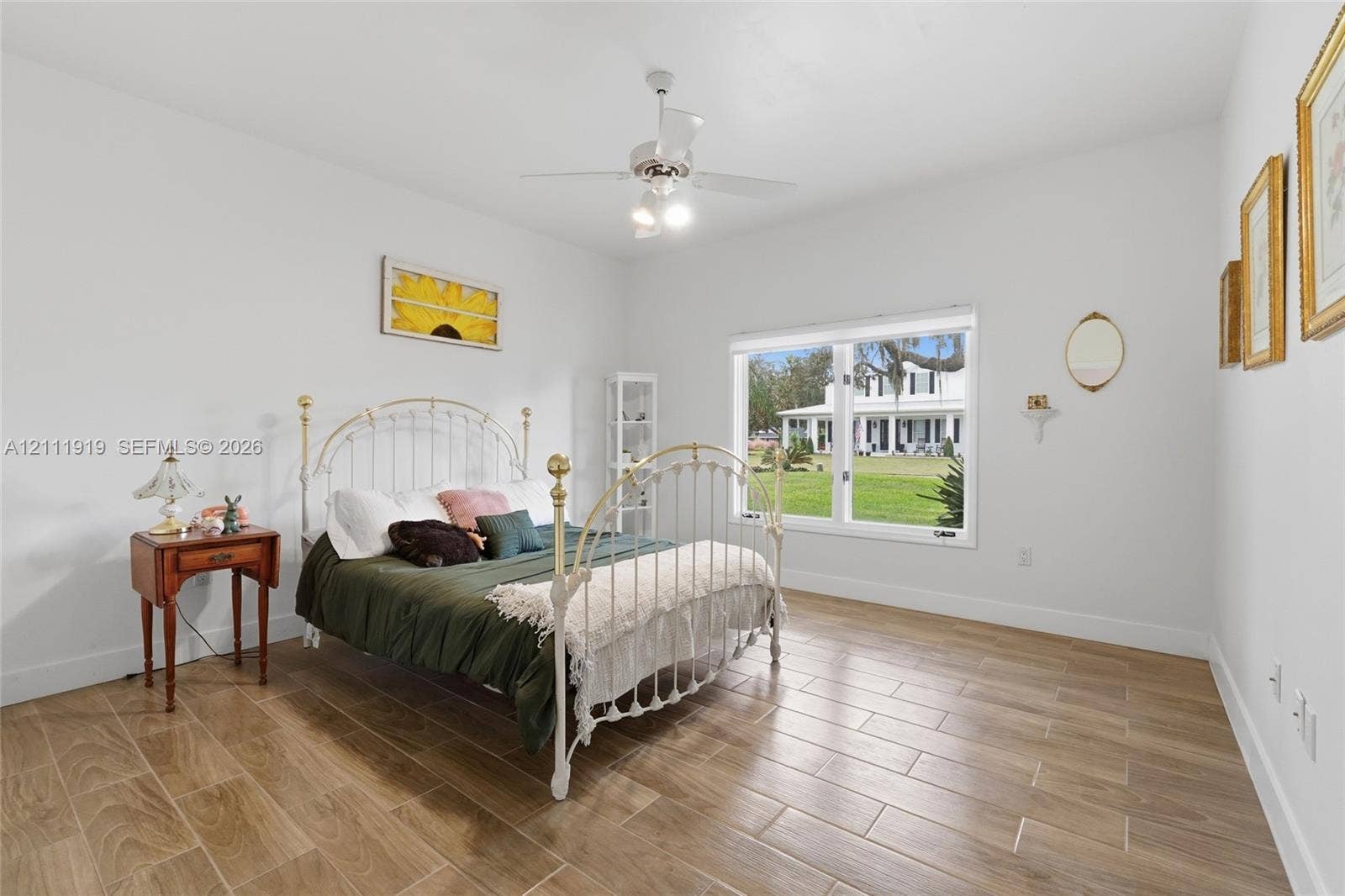 137 Arrowhead Lane, Haines City, FL 33844 Neutral-toned room featuring wood-finish flooring, a large window, and a white ceiling fan with integrated lighting