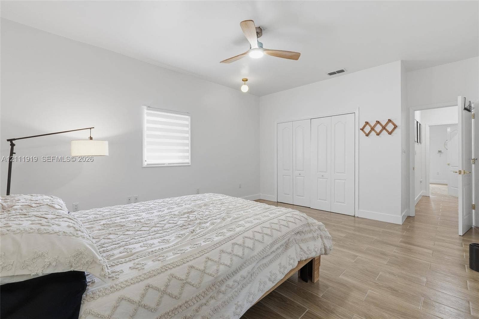 137 Arrowhead Lane, Haines City, FL 33844 Wood-finish flooring, ceiling fan with integrated light, dual-pane window with adjustable shade, and double-door closet cabinetry