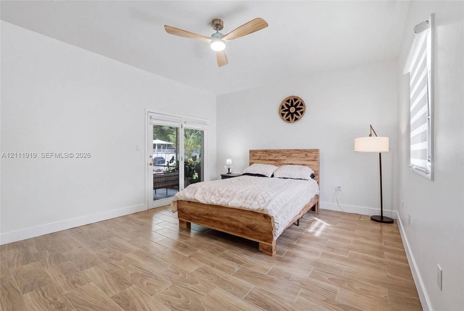 137 Arrowhead Lane, Haines City, FL 33844 Wood-finish tile flooring, recessed ceiling fan with integrated lighting, and glass-paneled sliding door