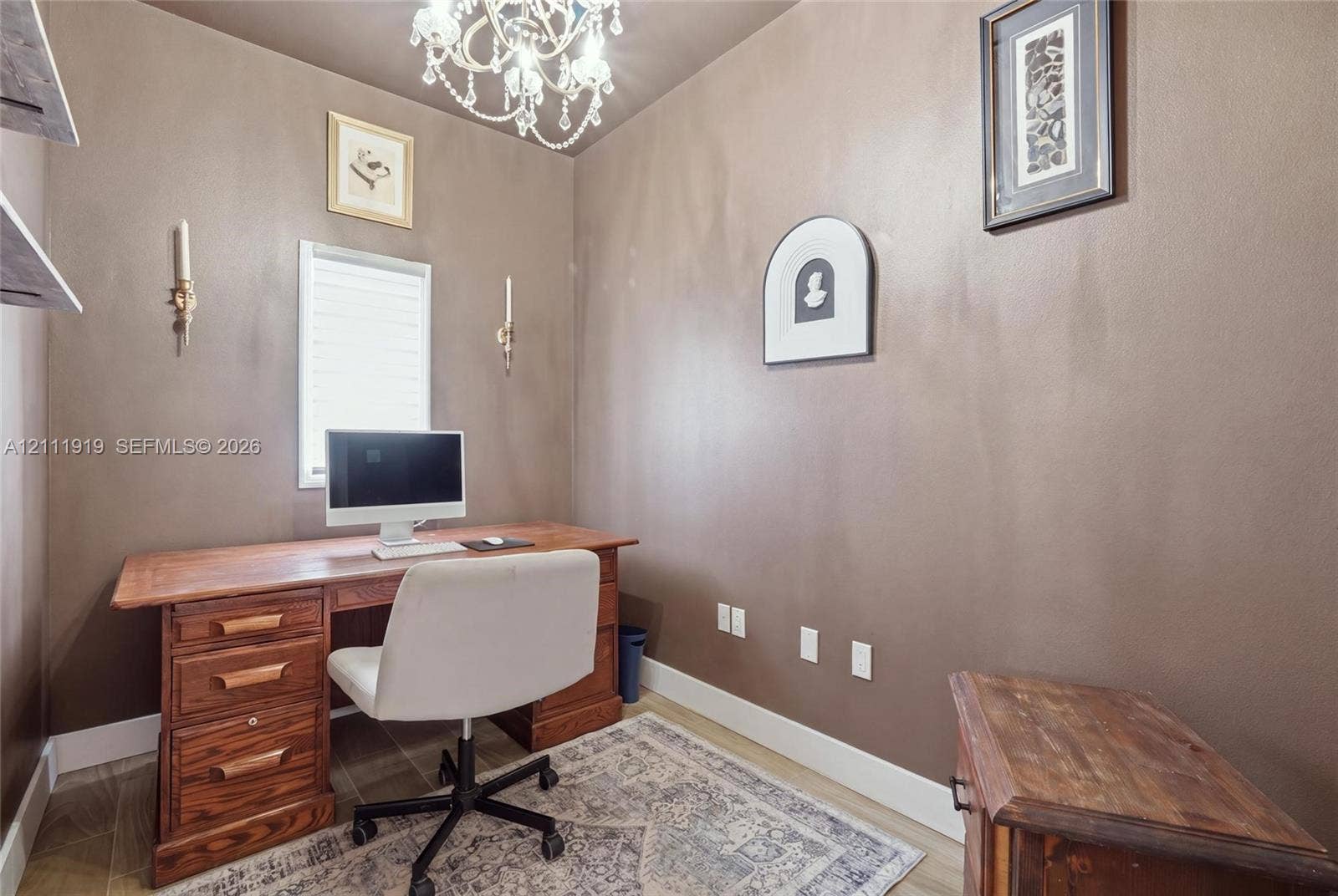 137 Arrowhead Lane, Haines City, FL 33844 Interior space featuring an ornate crystal chandelier, wall-mounted candle-style light fixtures, and wood-finish flooring