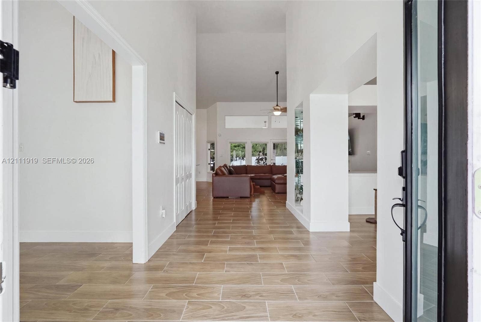 137 Arrowhead Lane, Haines City, FL 33844 Entryway featuring wood-finish tile flooring, vaulted ceilings, and a framed glass-panel entry door