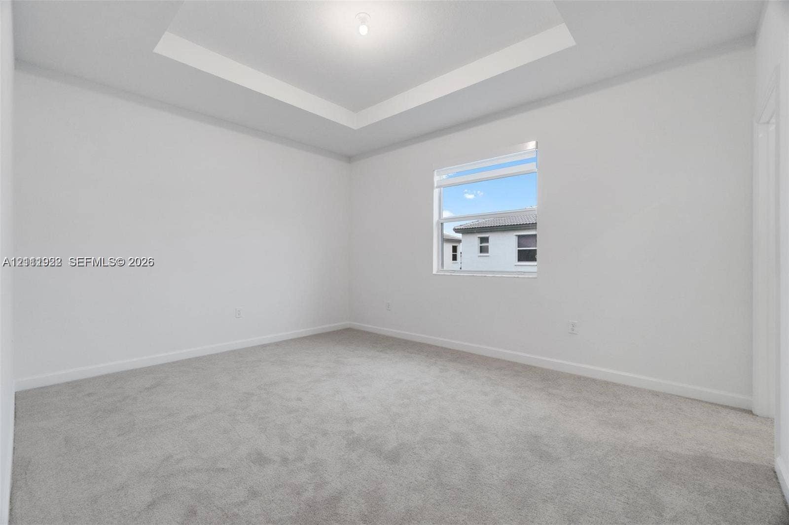 16281 SW 292nd Street, Homestead, FL 33033 Room featuring a tray ceiling, neutral wall coloring, and wall-to-wall carpeting