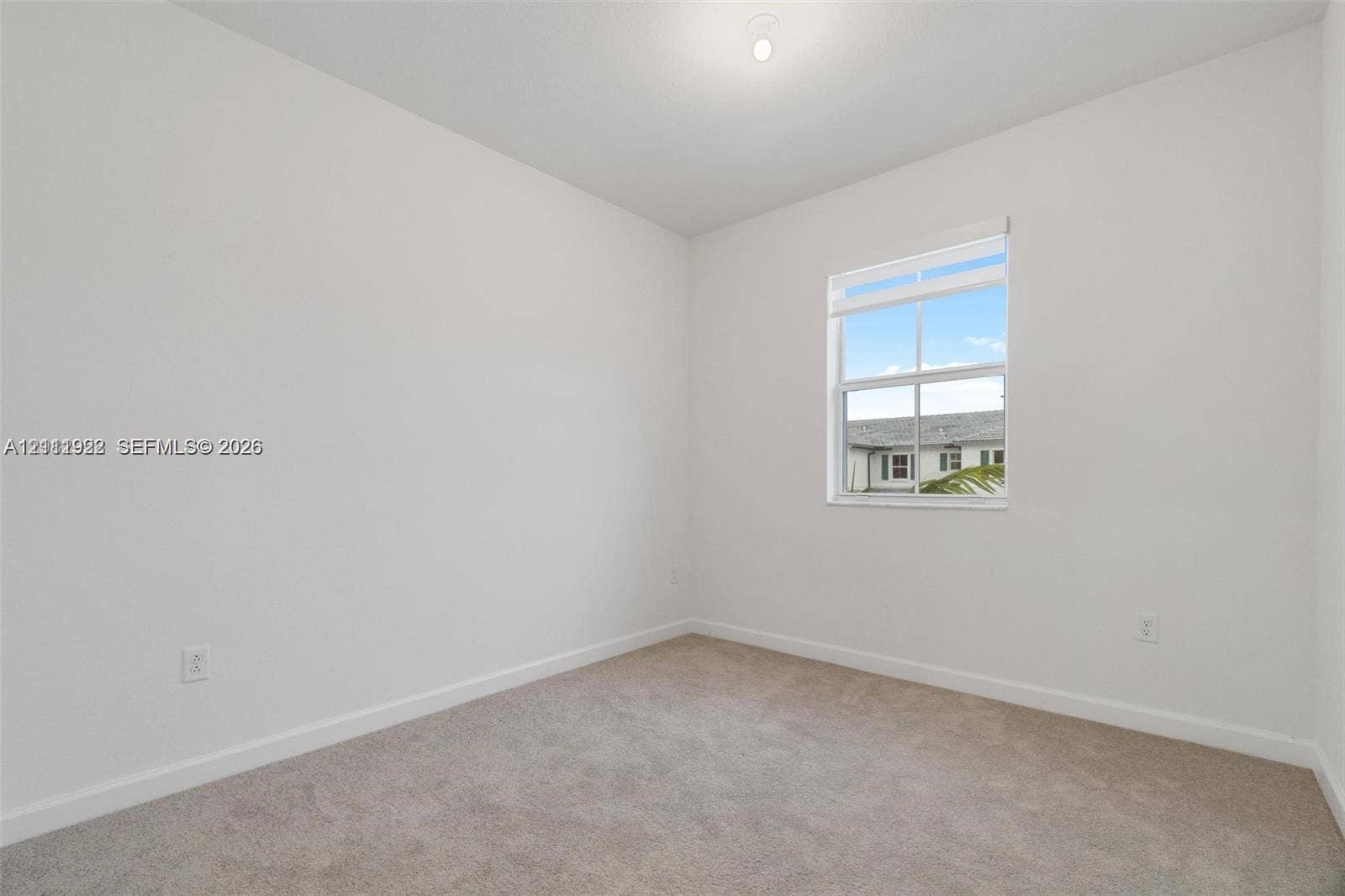 16281 SW 292nd Street, Homestead, FL 33033 Neutral-toned interior room featuring wall-to-wall carpeting, white walls, and a single-hung window with fitted blinds