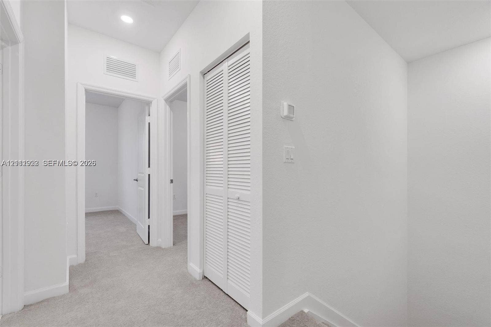 16281 SW 292nd Street, Homestead, FL 33033 Interior hall featuring wall-to-wall carpeting, recessed ceiling lighting, and a closet with louvered double doors