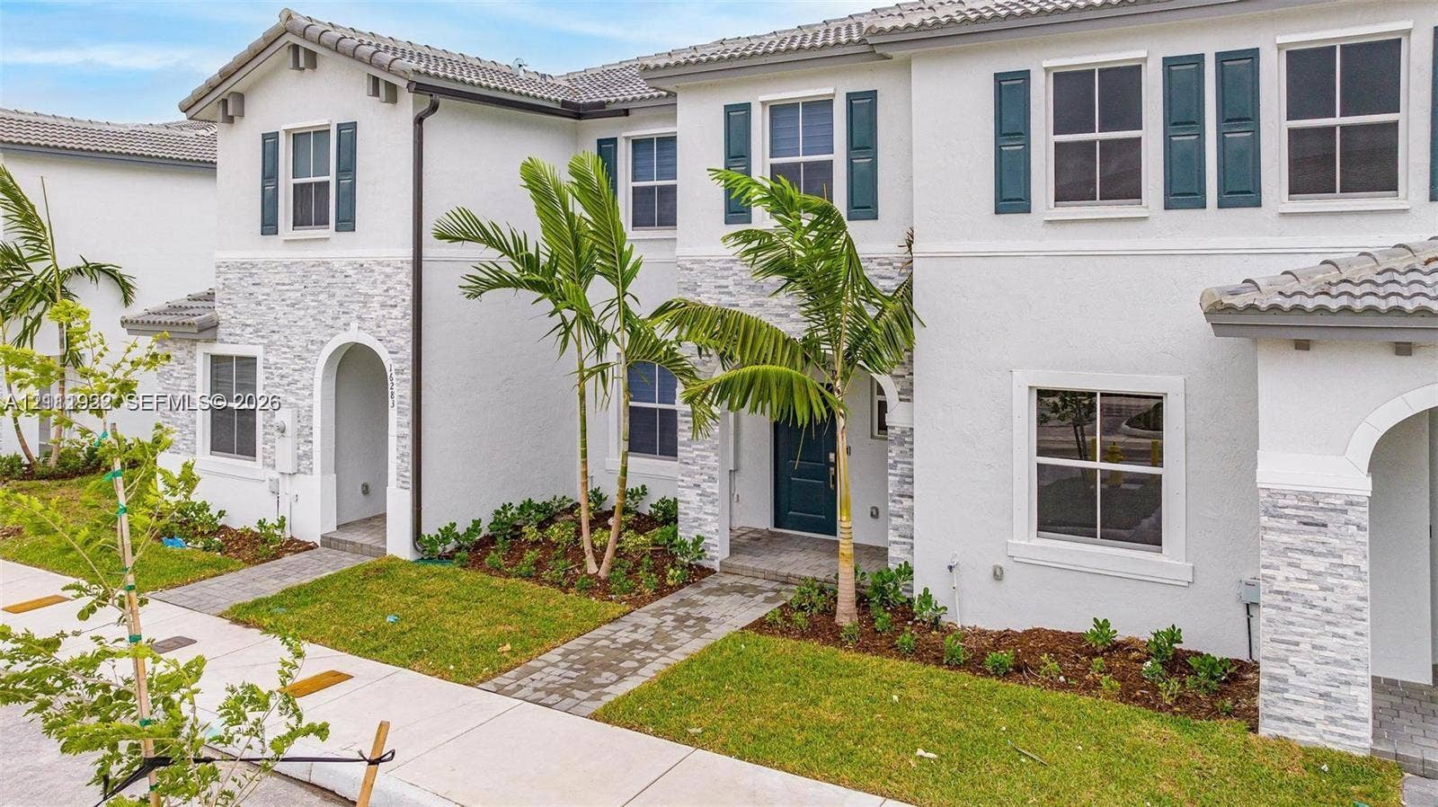 16281 SW 292nd Street, Homestead, FL 33033 Stucco exterior with stacked stone veneer accents, multi-pane windows with decorative shutters, tiled roof, and paver walkways