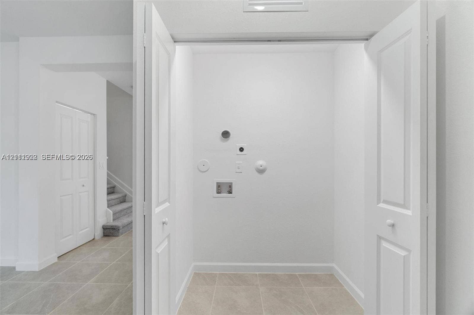 16281 SW 292nd Street, Homestead, FL 33033 Dedicated utility area featuring bi-fold doors, tile flooring, and integrated plumbing hookups