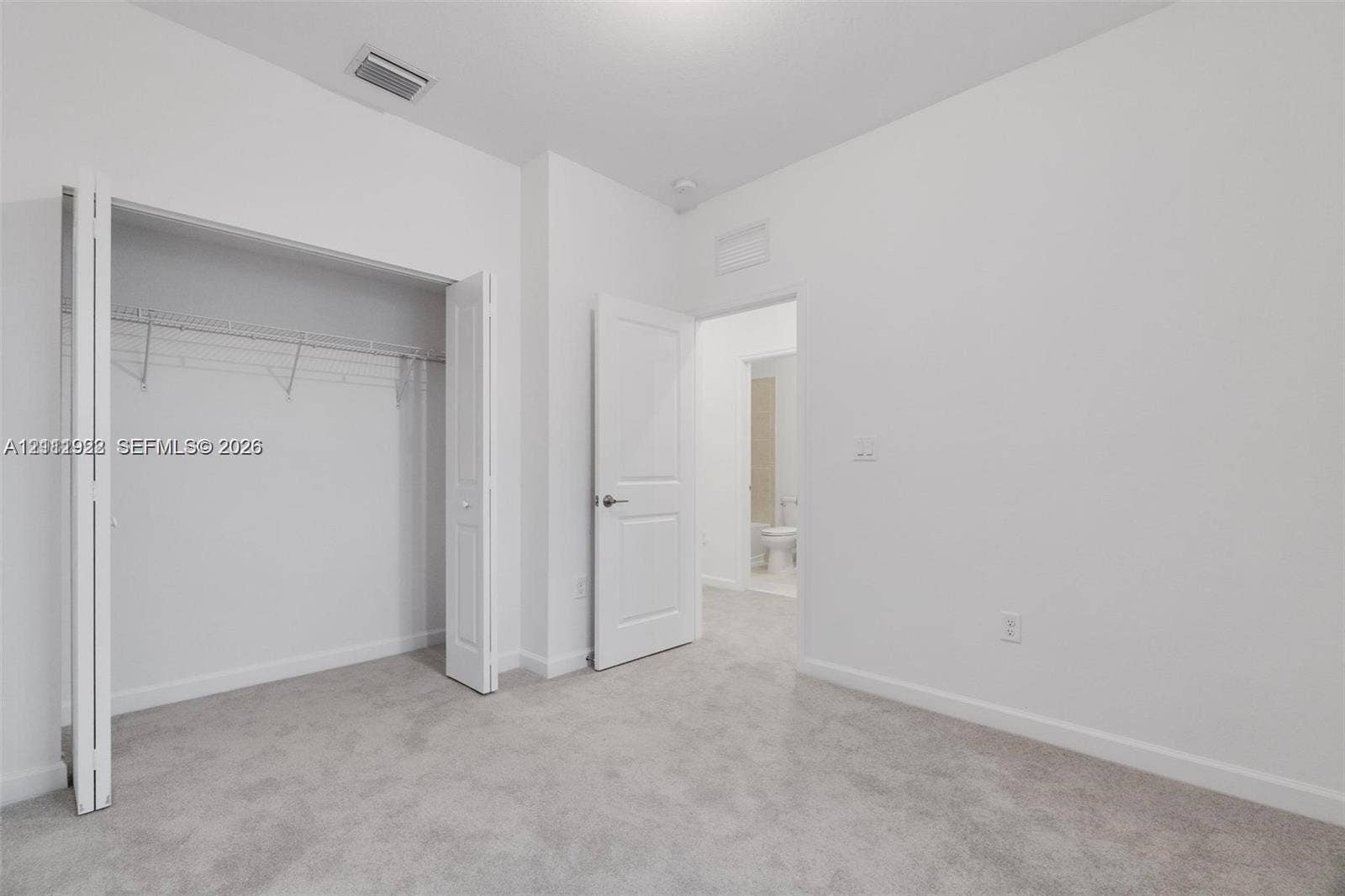 16281 SW 292nd Street, Homestead, FL 33033 Neutral wall color, wall-to-wall carpeting, bi-fold closet doors with built-in shelving, and solid-core interior doors