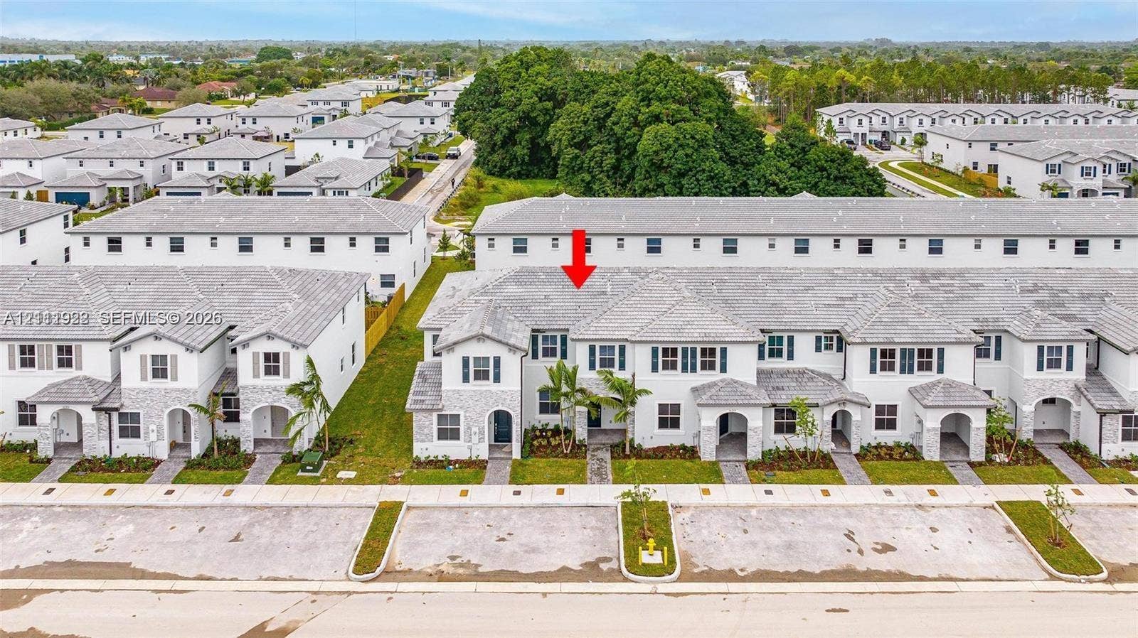 16281 SW 292nd Street, Homestead, FL 33033 Two-story multi-family residence featuring a light-toned stone and stucco exterior, a tiled roof, arched entryway, and louvered shutters
