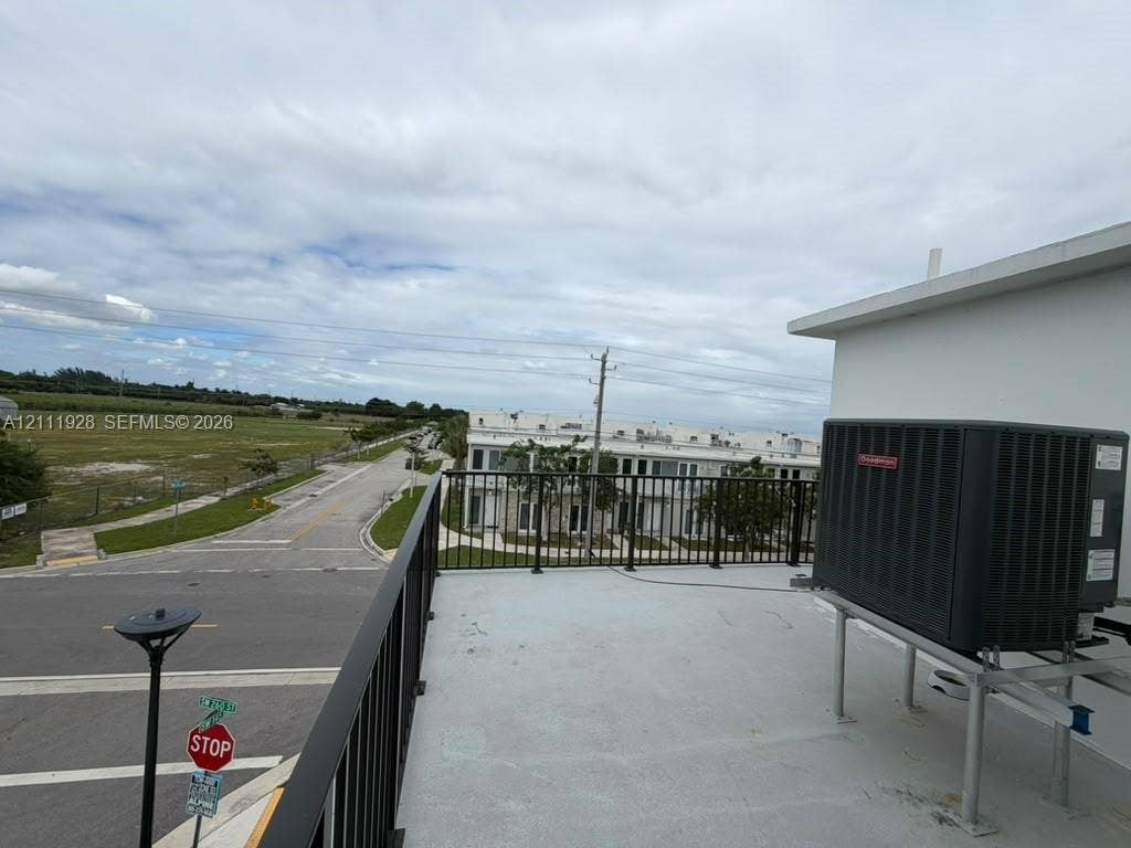 Rooftop terrace featuring a flat surface, metal railing, and external HVAC unit