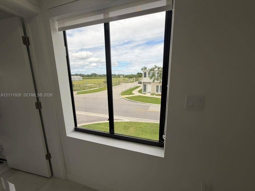 Large, black-framed picture window featuring a retractable roller shade
