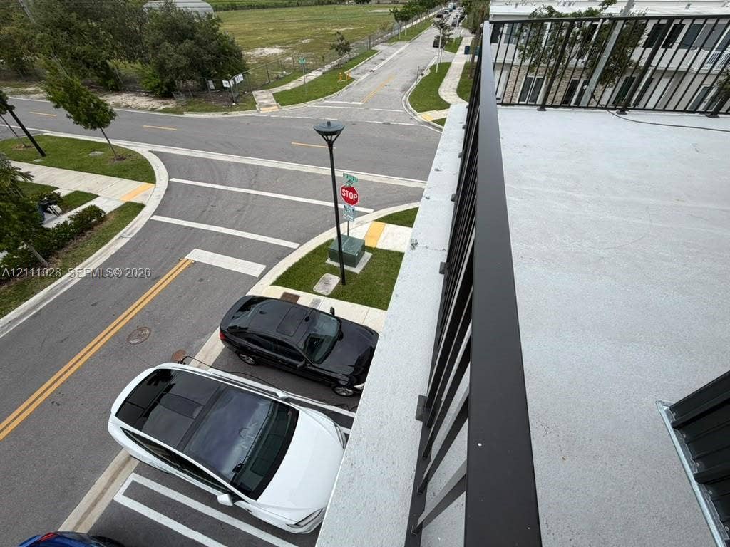 Elevated balcony featuring a smooth surface deck and a black metal railing