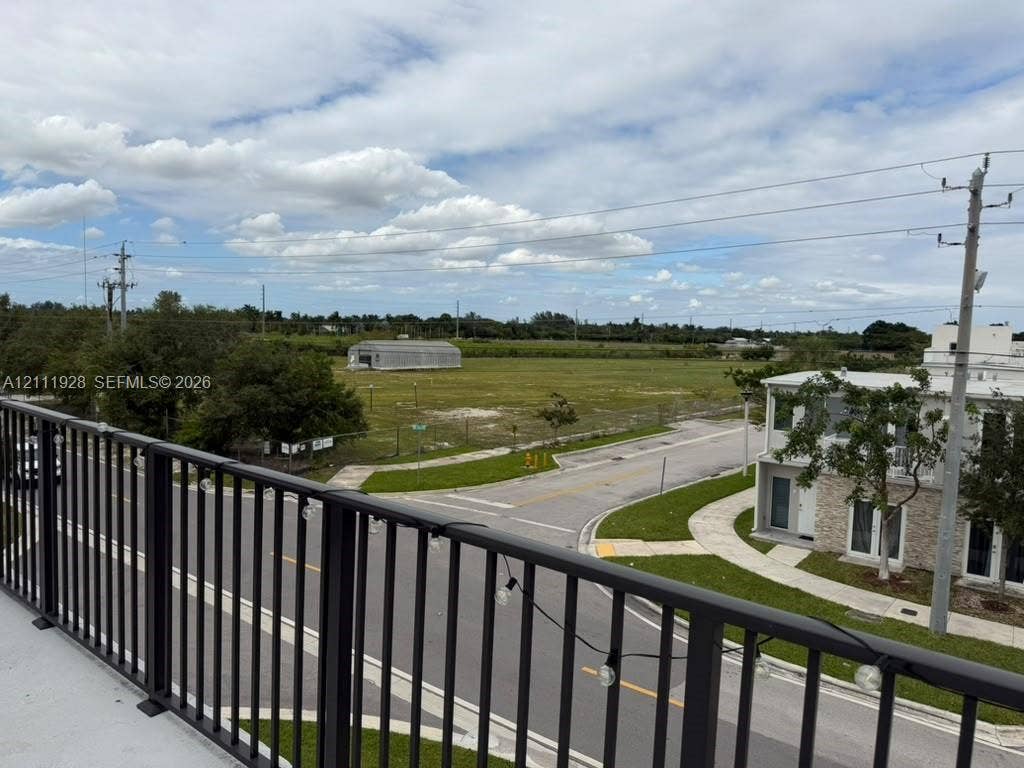 Elevated balcony with a black metal railing and expansive, open-terrain surroundings