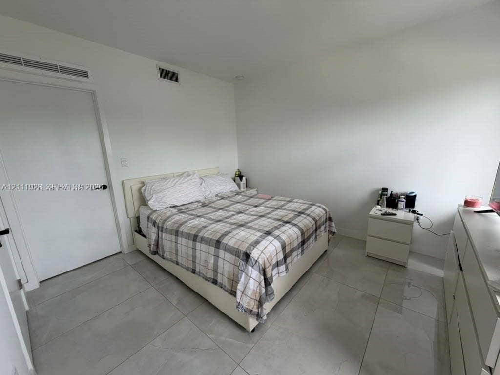 Large-format tile flooring, white interior walls, and solid-core doors with matte black hardware