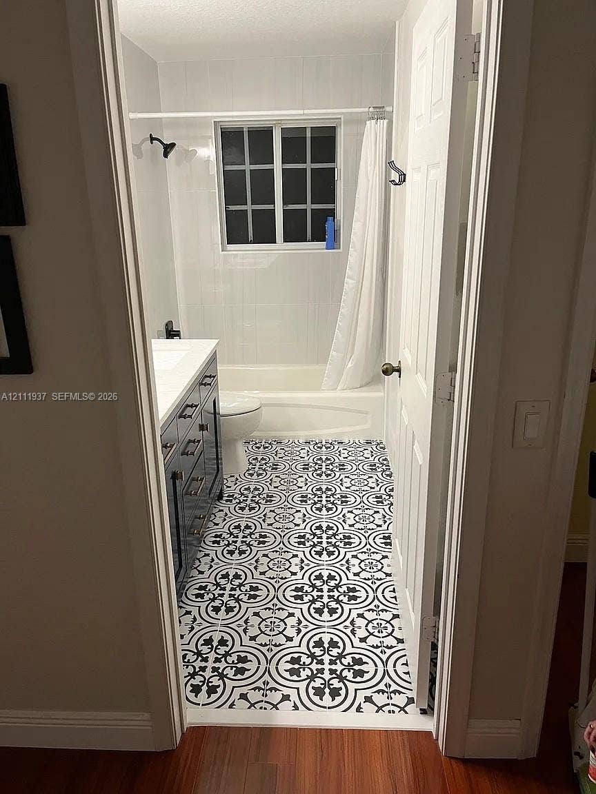 869 Nandina Drive, #869, Weston, Weston, FL 33327 Bathroom featuring patterned tile flooring, a dark-toned vanity with a white countertop, and a shower-tub combination with white wall tile