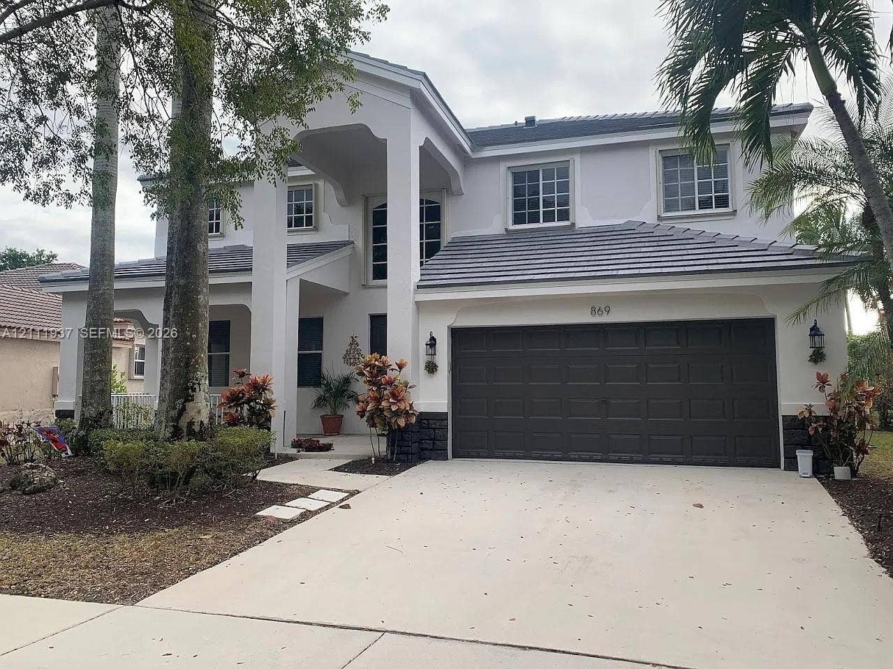 869 Nandina Drive, #869, Weston, Weston, FL 33327 Two-story residence featuring a tile roof, stucco exterior, covered entryway, and a two-car garage
