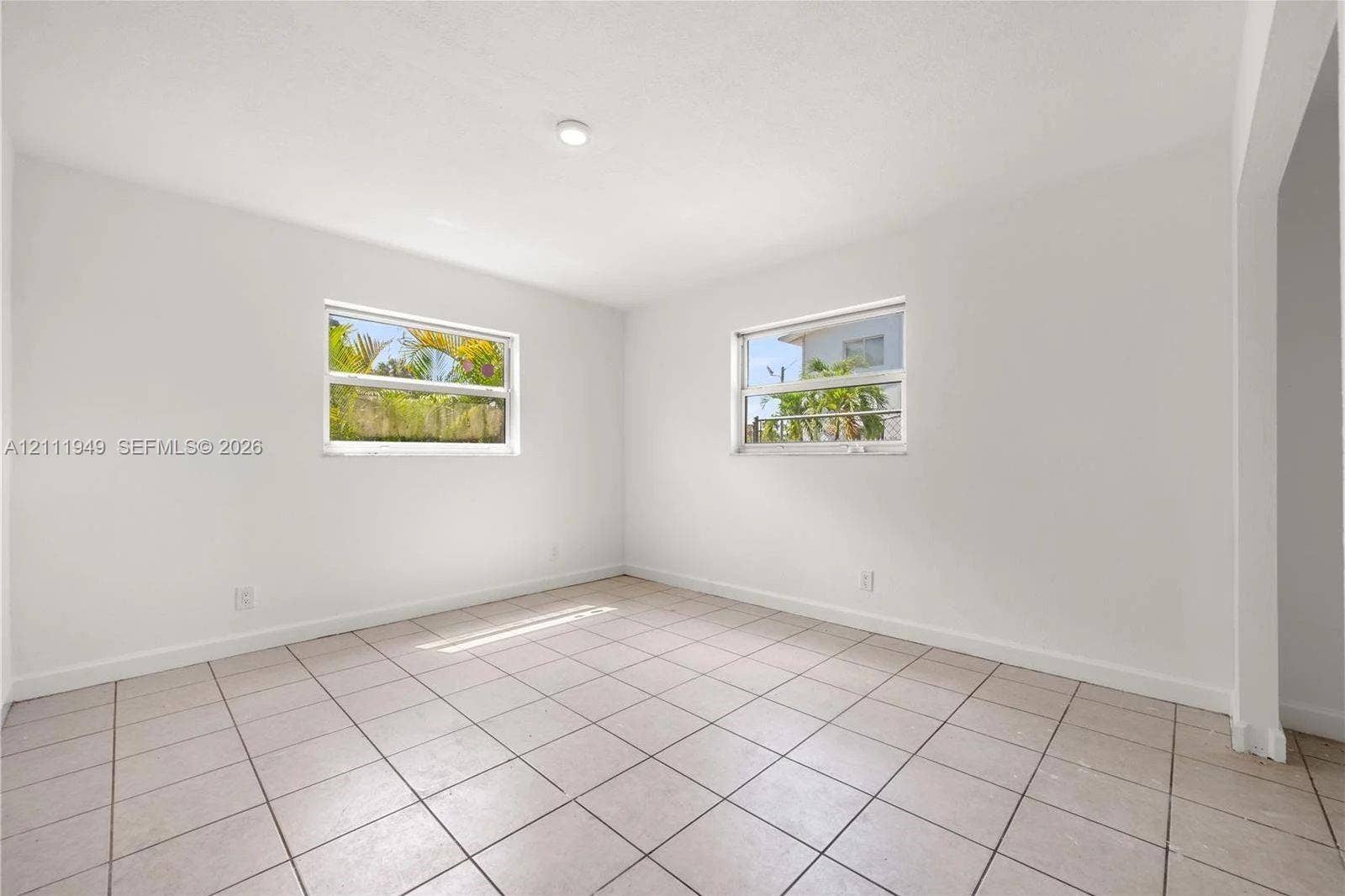Interior room featuring neutral wall paint, tile flooring, and dual single-hung windows