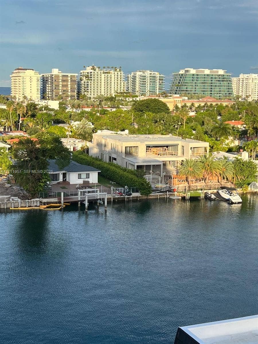 Waterfront property featuring private dockage, concrete seawall, mature perimeter landscaping, and multi-level structural design