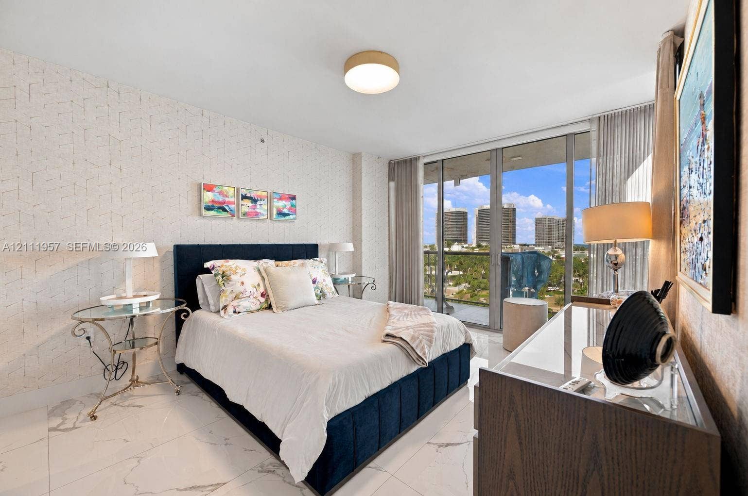 Polished stone-finish flooring, textured wall covering, and floor-to-ceiling glass sliding doors opening to a private balcony