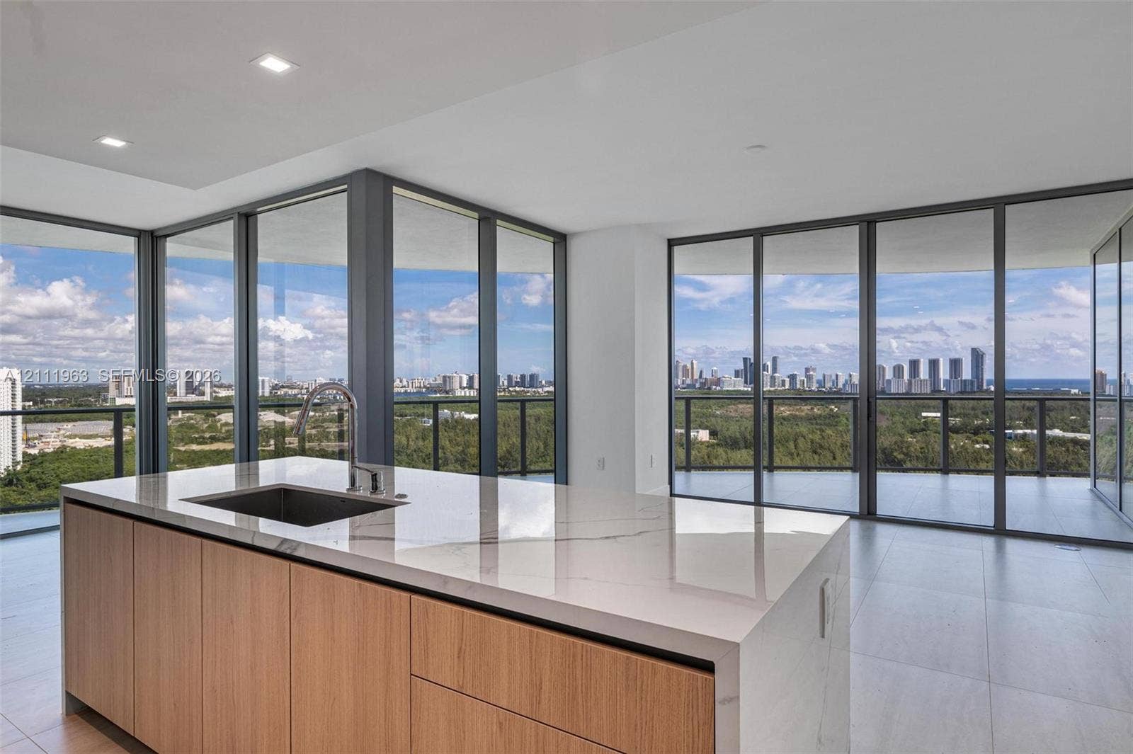 Kitchen featuring a waterfall island with a stone-finish countertop, wood-finish cabinetry, built-in double wall oven, and recessed lighting