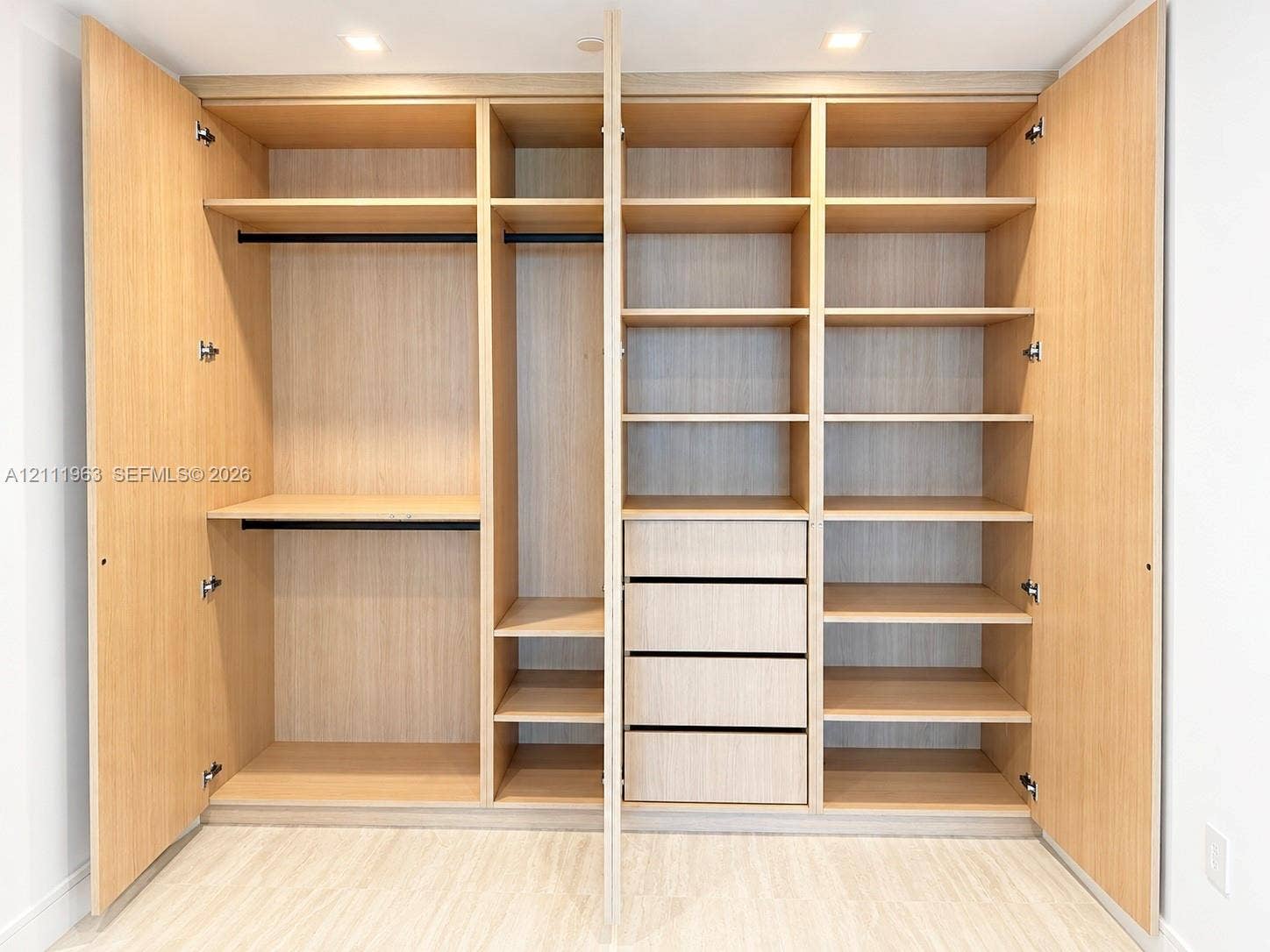 Interior space featuring neutral white walls, recessed ceiling lighting, and large-format tile flooring