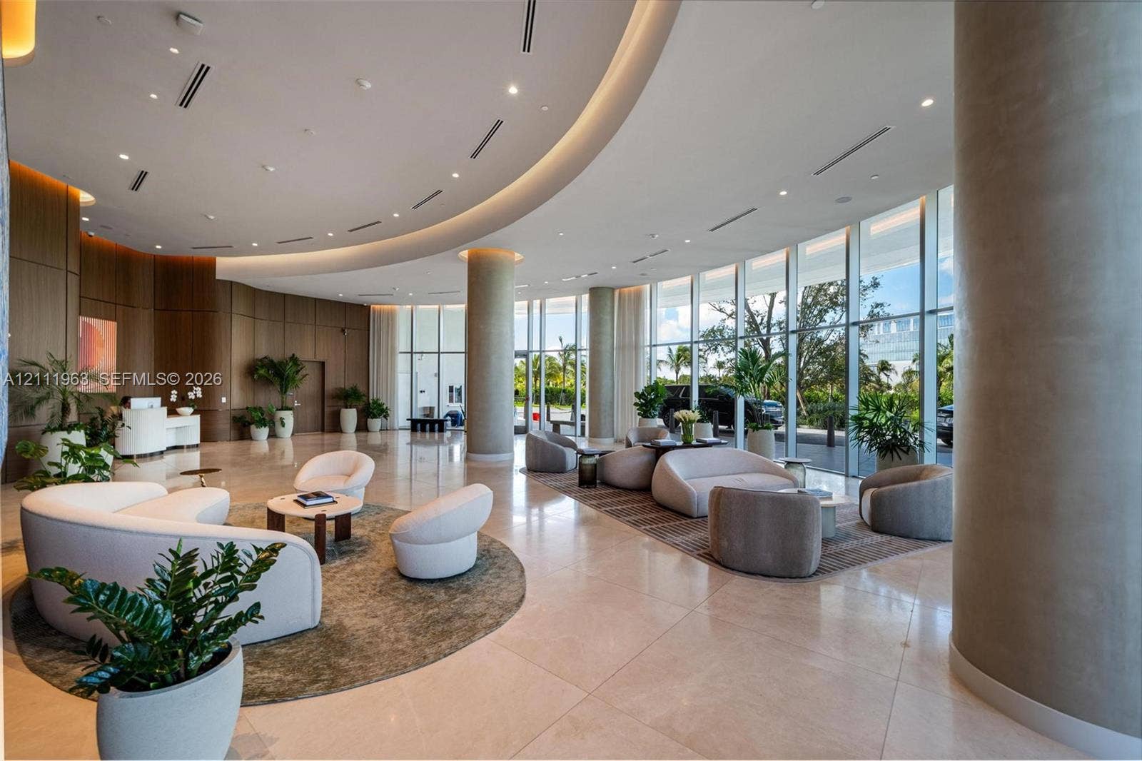 Floor-to-ceiling windows, polished stone flooring, recessed ceiling lighting, and built-in wood shelving